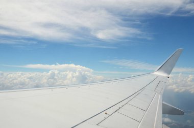 Güzel bulut manzarası ve pencereden uçağın kanadı
