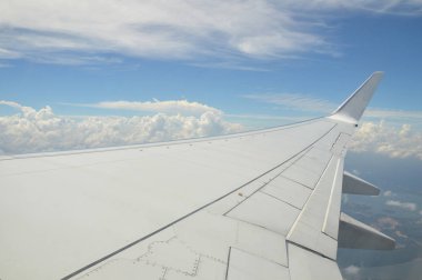 Güzel bulut manzarası ve pencereden uçağın kanadı
