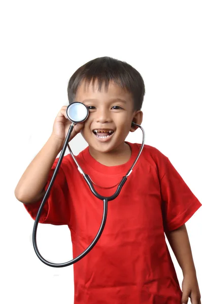 亚洲小男孩穿着红色衬衫拿着听诊器与白色背景 — 图库照片