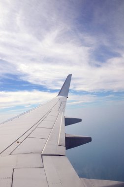 Güzel bulut manzarası ve pencereden uçağın kanadı