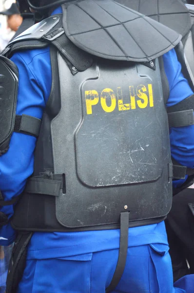 Indonessian Polis siyah anti-isyan güvenlik yelekgiyiyor
