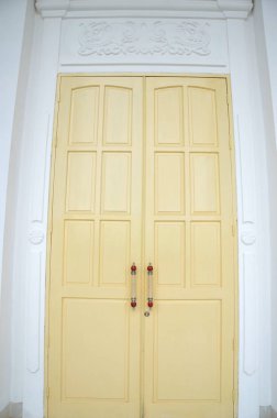 Beyaz binada ahşap kapılar