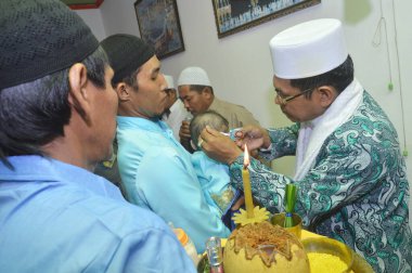 Tarakan, Endonezya. 12 Mart 2017 'de bazı alimler anne ve baba tarafından tutulan bebek için dua eder ve dua ederler.