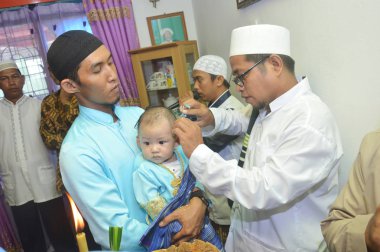Tarakan, Endonezya. 12 Mart 2017 'de bazı alimler anne ve baba tarafından tutulan bebek için dua eder ve dua ederler.