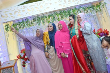 TARAKAN, INDONESIA, 16th January 2016 : : beautiful asian girsl selfie with a couple bride 