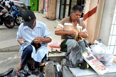 Tarakan, Endonezya - 26 Mart 2016: Mağazada iki ayakkabı tamircisi