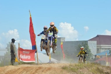 TARAKAN, İndonezya. 13 Mayıs 20176 Grasstrack motosiklet yarışçısı bir tepecikte uçuyor.