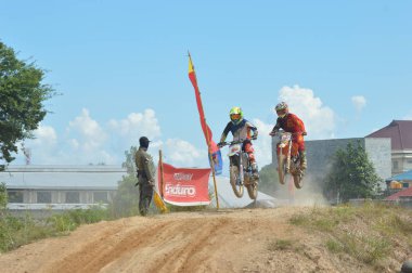 TARAKAN, İndonezya. 13 Mayıs 20176 Grasstrack motosiklet yarışçısı bir tepecikte uçuyor.