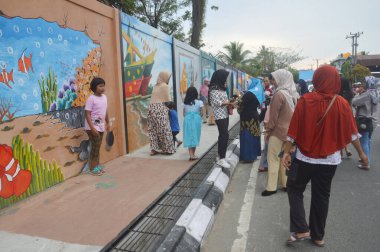 Tarakan, Endonezya - 5 Ağustos 2017: İnsanlar beton duvardaki üç boyutlu duvar resmi üzerinde poz verdiler