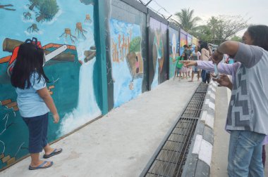 Tarakan, Endonezya - 5 Ağustos 2017: İnsanlar beton duvardaki üç boyutlu duvar resmi üzerinde poz verdiler