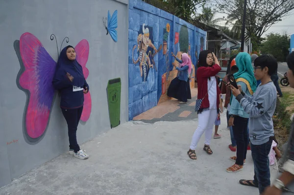 Tarakan, Endonezya - 5 Ağustos 2017: İnsanlar beton duvardaki üç boyutlu duvar resmi üzerinde poz verdiler