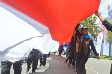 TARAKAN - İndonezya. 18 Ağustos 2019, Endonezya Cumhuriyeti 'nin bağımsızlık gününü kutlamak için düzenlenen karnaval yürüyüşlerindeki en uzun kırmızı ve beyaz Endonezya bayrak alayı.