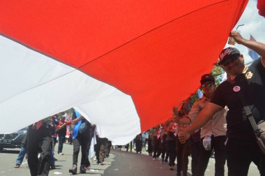 TARAKAN - İndonezya. 18 Ağustos 2019, Endonezya Cumhuriyeti 'nin bağımsızlık gününü kutlamak için düzenlenen karnaval yürüyüşlerindeki en uzun kırmızı ve beyaz Endonezya bayrak alayı.