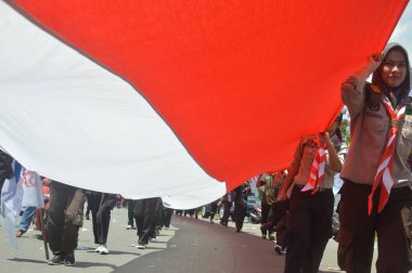 TARAKAN - İndonezya. 18 Ağustos 2019, Endonezya Cumhuriyeti 'nin bağımsızlık gününü kutlamak için düzenlenen karnaval yürüyüşlerindeki en uzun kırmızı ve beyaz Endonezya bayrak alayı.