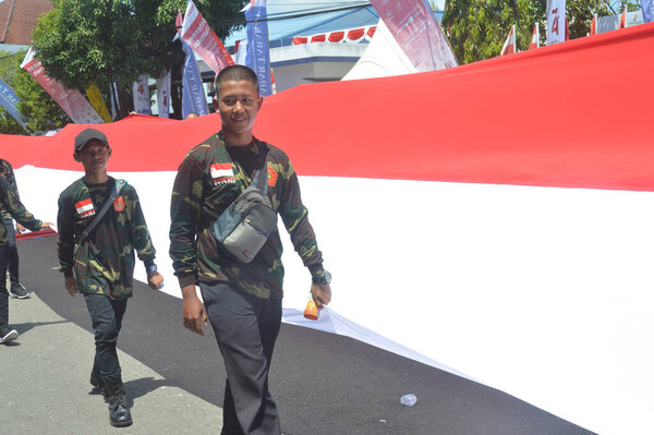 ТАРАКАН - ИНДОНЕЗИЯ. 18 августа 2019 года - самая длинная процессия индонезийского красно-белого флага на карнавальных маршах в честь Дня независимости Индонезии
