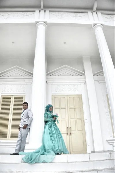 2017年2月19日 印度尼西亚新婚夫妇穿着绿色穆斯林长袍在白楼举行婚礼前拍照 — 图库照片