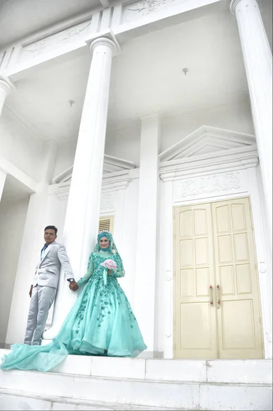 2017年2月19日 印度尼西亚新婚夫妇穿着绿色穆斯林长袍在白楼举行婚礼前拍照 — 图库照片