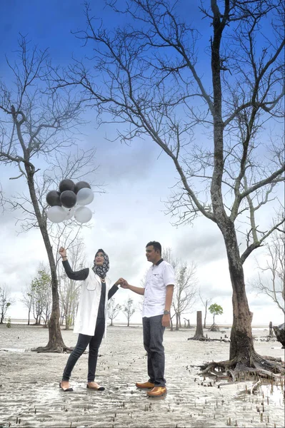 2017年2月19日 印度尼西亚新婚夫妇穿着穆斯林休闲装在海滩上举行婚礼前拍照 — 图库照片