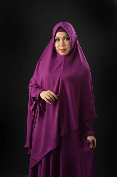 黒の背景に隔離された紫色のスカーフを着た美しいイスラム教徒の女性の肖像画 — ストック写真