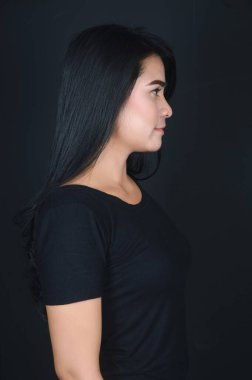 Siyah arka plan fotoğraf stüdyosunda siyah fotoğraf çeken Asyalı güzel bir kızın portresi.