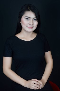 Siyah arka plan fotoğraf stüdyosunda siyah fotoğraf çeken Asyalı güzel bir kızın portresi.