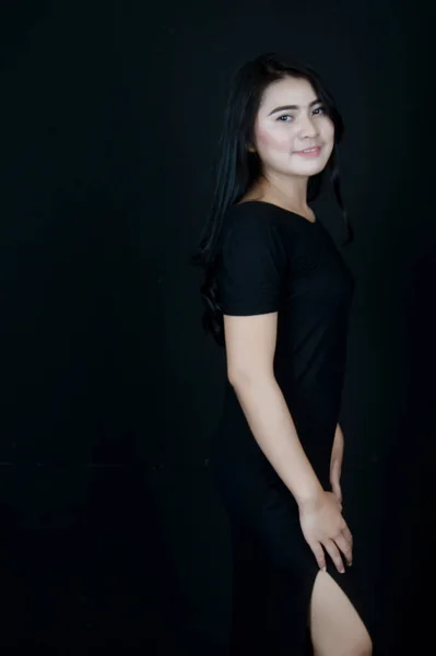 在一个黑色背景摄影工作室拍摄的身穿黑色摄影服的丑陋亚洲女孩的肖像 — 图库照片