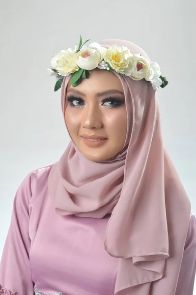 肖像画ピンクのイスラム教徒のシャツと花のバンドを着た美しいイスラム教徒のアジアの女の子 白い背景を持つスタジオの写真 — ストック写真
