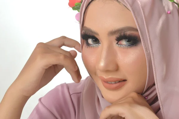 肖像画ピンクのイスラム教徒のシャツと花のバンドを着た美しいイスラム教徒のアジアの女の子 白い背景を持つスタジオの写真 — ストック写真