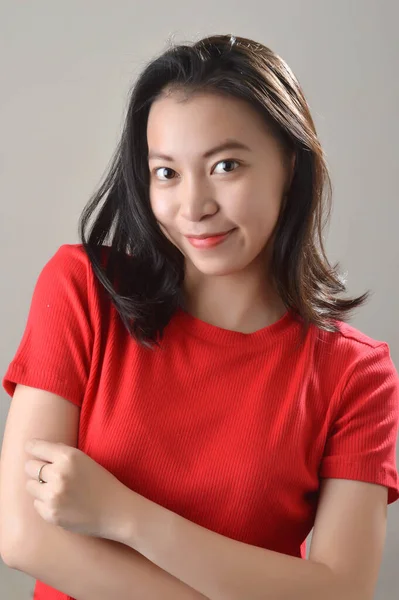 美しいアジア系中国人の女の子白い背景写真スタジオで顔の表情をした赤いカジュアルな服を着て — ストック写真