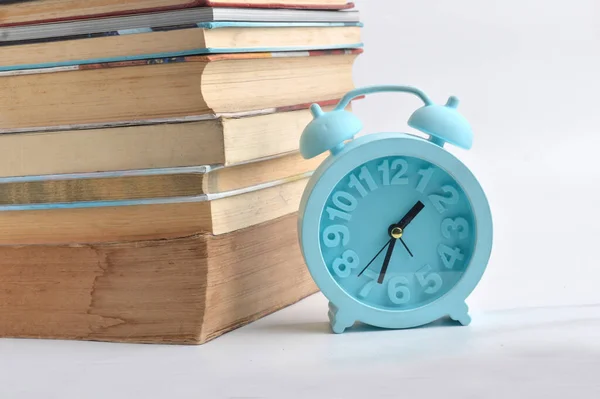 本の山と白い背景の青い目覚まし時計 — ストック写真