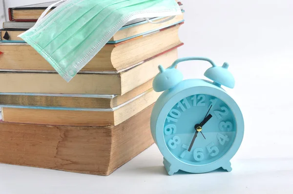 Stack Books Blue Alarm Clock Surgery Mask White Background Study — Stock Photo, Image