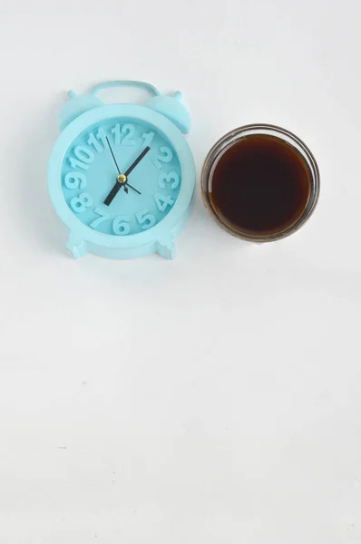 白を基調としたブラックコーヒーとブルー目覚まし時計 コーヒータイムコンセプト — ストック写真