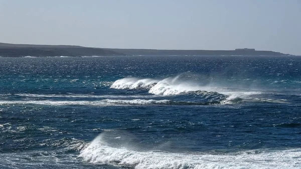 Ondas oceânicas na costa rochosa negra — Fotografia de Stock