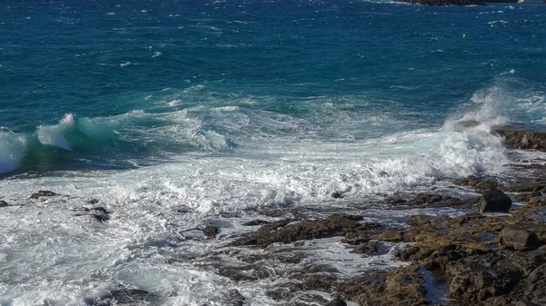 Ondas oceânicas na costa rochosa negra — Fotografia de Stock