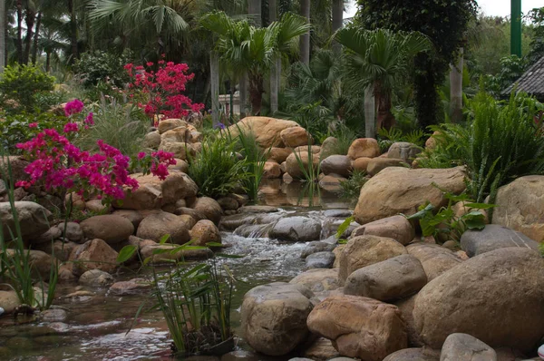 Prachtig park met mooie bloemen en waterval — Stockfoto