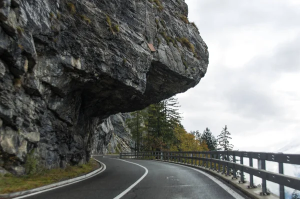 Gefährliche Straße zwischen Felsen in den Alpen lizenzfreie Stockbilder