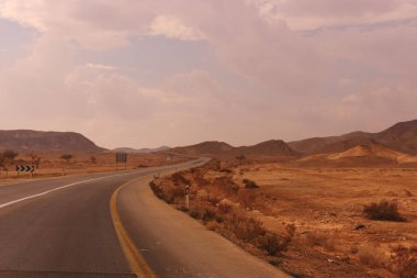 Asfalt yolun ortasında kırmızı kum tepeleri İsrail 