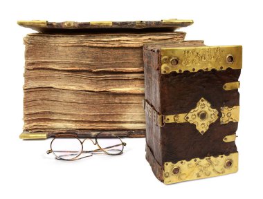 Beyaz arka planda altın süpürge detaylarıyla süslenmiş çok eski bir kitabın fotoğrafı.