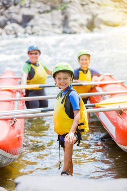 Sevimli çocuk kask ve canlı yelek katamaran üzerinde rafting için hazır
