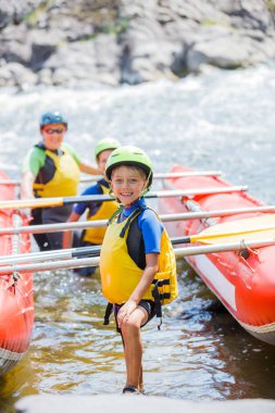 Sevimli çocuk kask ve canlı yelek katamaran üzerinde rafting için hazır