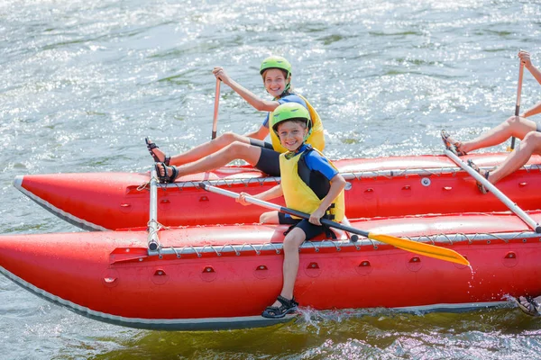 Søt gutt i hjelm og padleåre klar til rafting på katamaranen – stockfoto