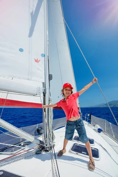 Petit garçon capitaine à bord d'un voilier en croisière d'été. Voyage aventure, yachting avec enfant en vacances en famille . — Photo