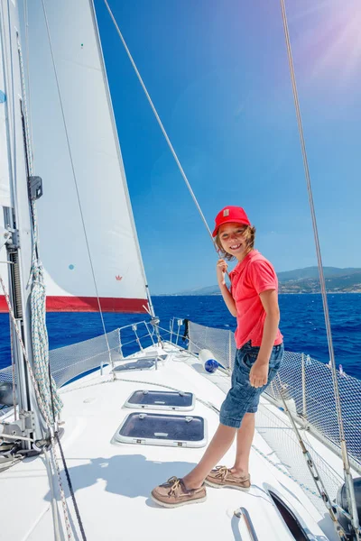 Petit garçon capitaine à bord d'un voilier en croisière d'été. Voyage aventure, yachting avec enfant en vacances en famille . — Photo