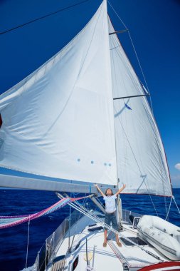 Küçük çocuk yaz gezisinde yelkenli yatında. Seyahat macerası, çocuğuyla yat gezisi..