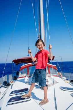 Küçük çocuk yaz gezisinde yelkenli yatında. Seyahat macerası, çocuğuyla yat gezisi..