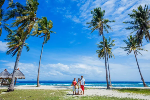 Молода сім'я з двома дітьми на тропічному пляжі — стокове фото