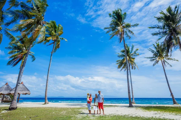 Familia joven con dos niños en la playa tropical —  Fotos de Stock