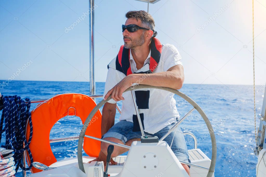 Young man sailing yacht