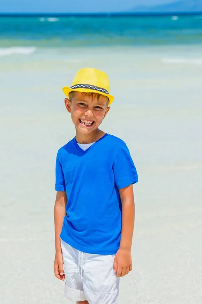 Happy child in yellow hat on beach. — Stock Photo, Image