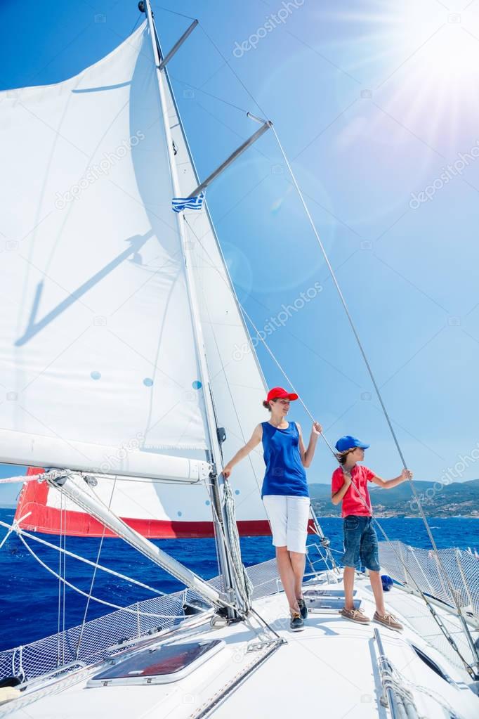 Boy with his sister on board of sailing yacht on summer cruise. Travel adventure, yachting with child on family vacation.